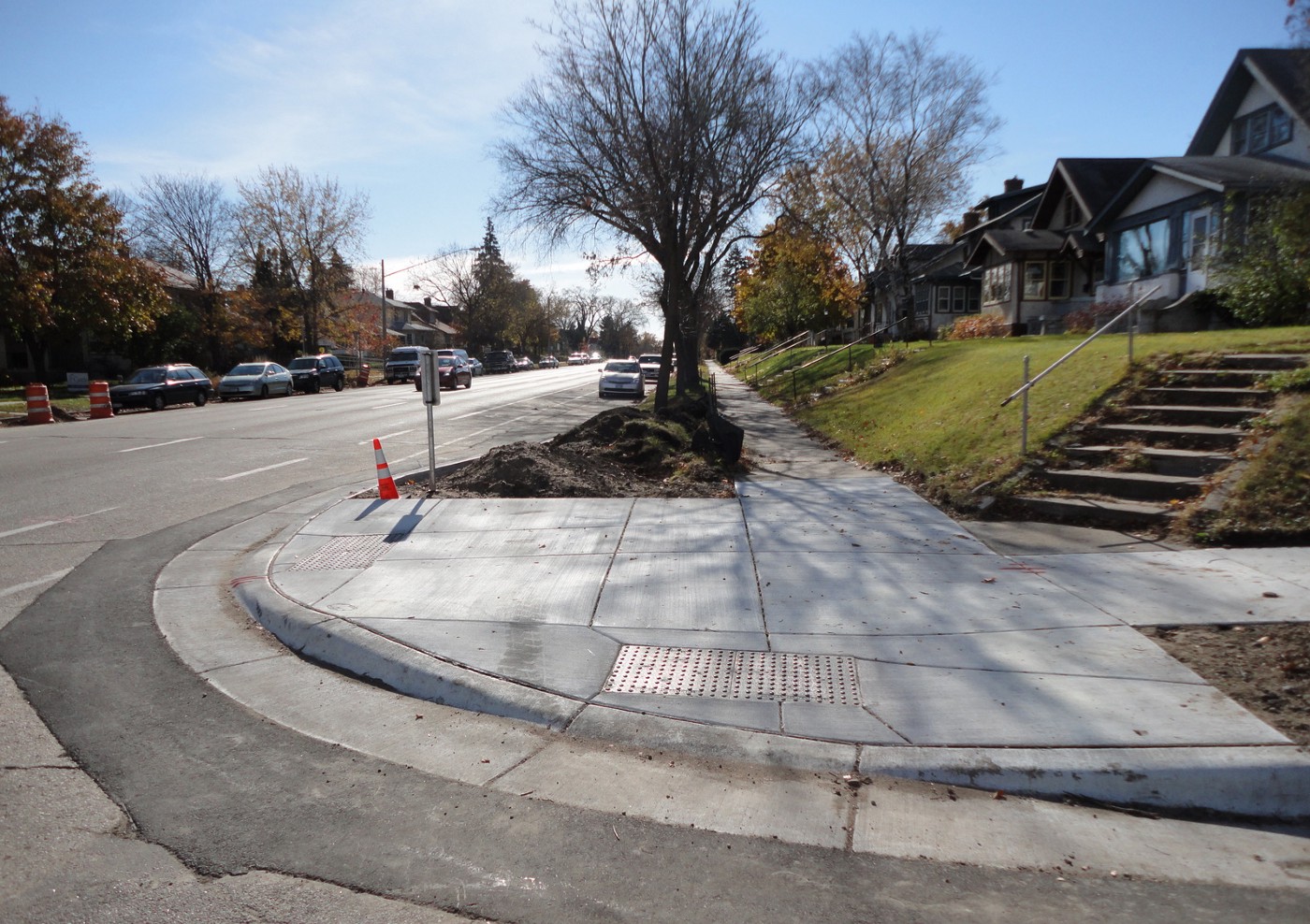 Curb cut of the sidewalk allowing easy access for a wheeled apparatus.