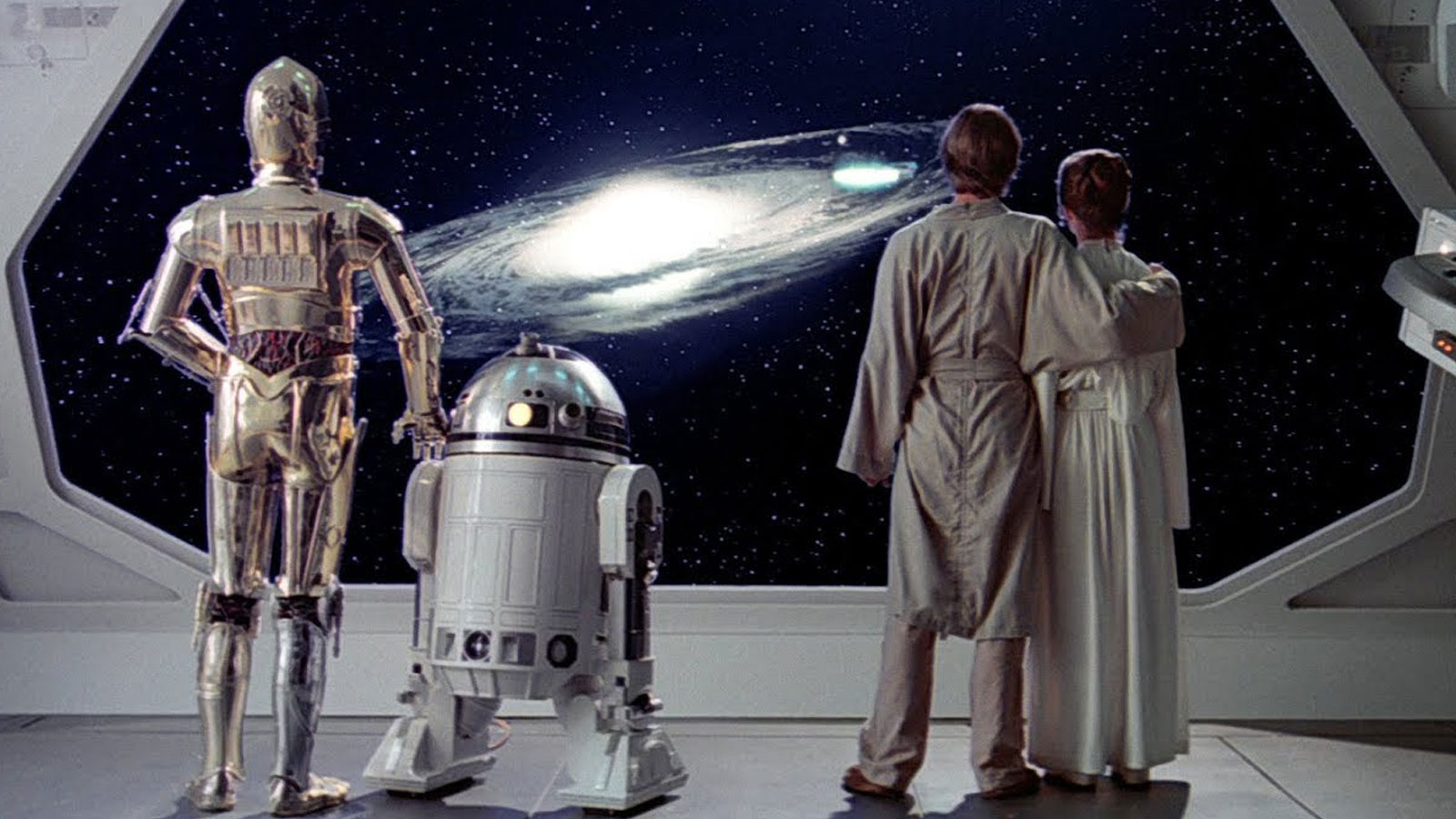 Luke, Leia, C3-PO, and R2-D2 looking out of a starship at a galaxy.